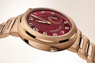 A close-up of the case of the Hermès Cut Le Temps Suspendu with red-tinted dial