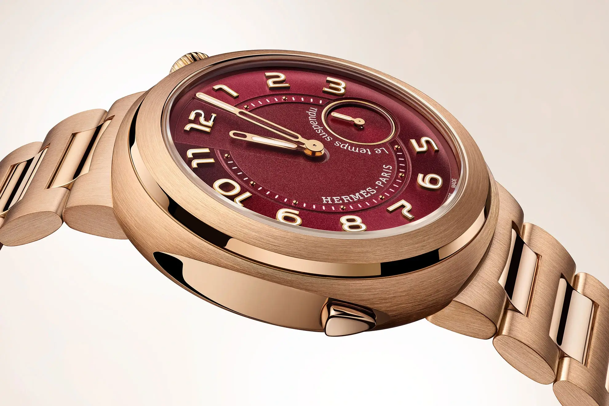 A close-up of the case of the Hermès Cut Le Temps Suspendu with red-tinted dial