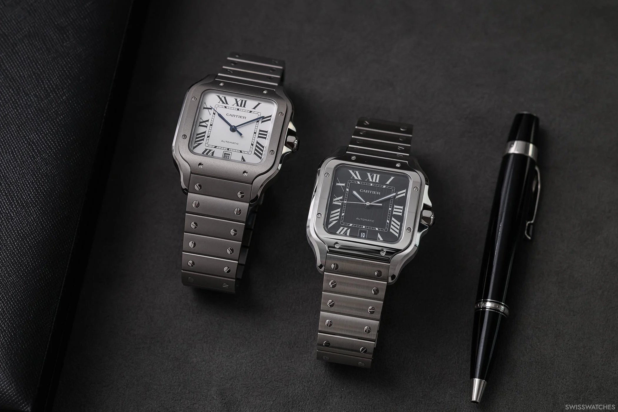 Direkter Vergleich der Cartier Santos de Cartier Referenzen CRWSSA0089 in Titan und CRWSSA0096 in Stahl, mit Fokus auf Unterschiede bei Zifferblatt und Gehäuse.