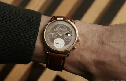 Hermès Slim d’Hermès Perpetual Calendar in Roségold am Handgelenk mit braunem Lederband und ewigen Kalenderanzeigen.