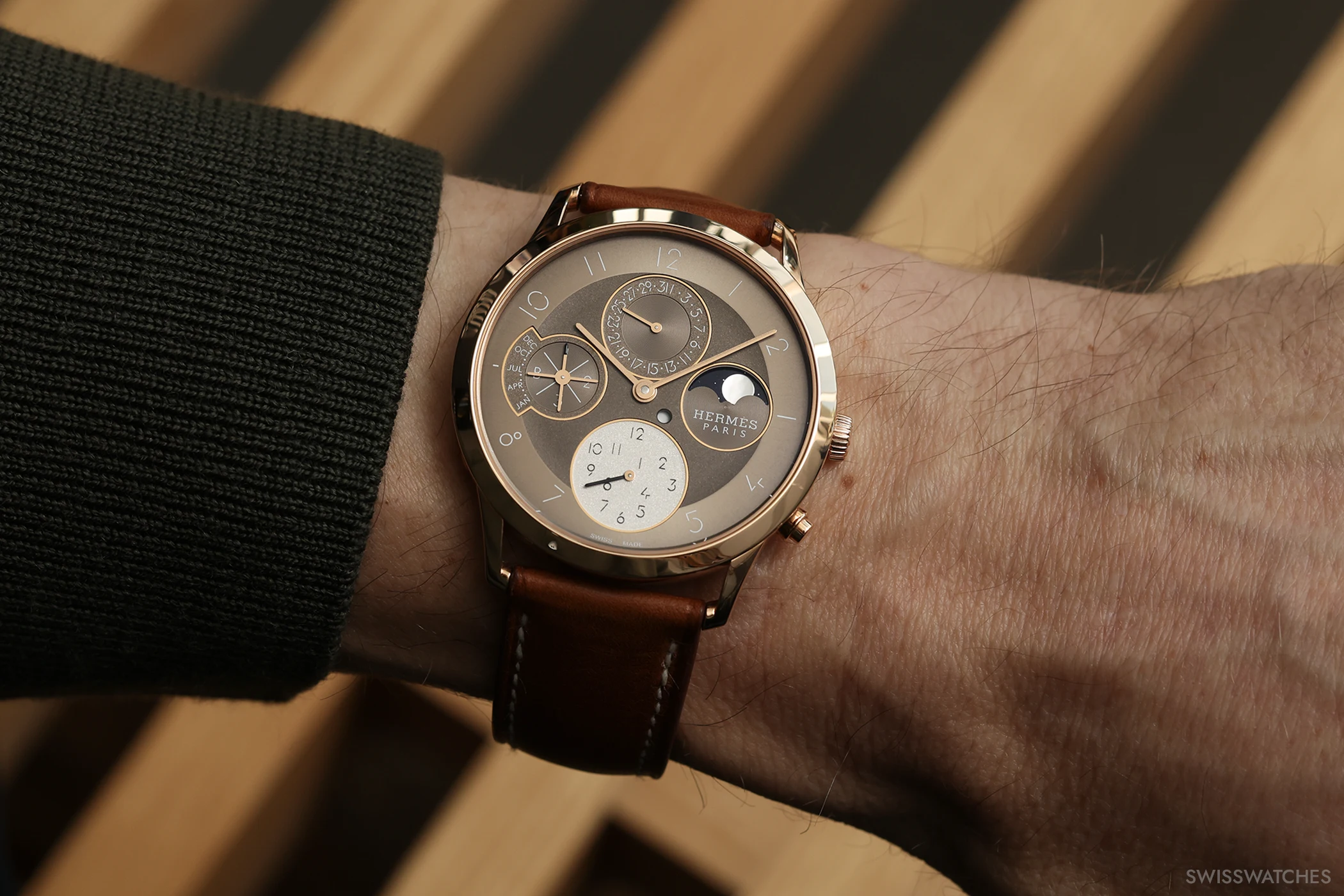 Hermès Slim d’Hermès Perpetual Calendar in Roségold am Handgelenk mit braunem Lederband und ewigen Kalenderanzeigen.