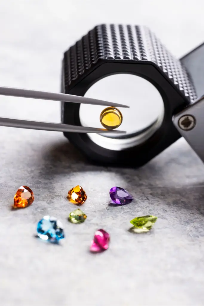 Farbedelsteine mit Pinzette und Lupe für das Bulgari-Modell Tubogas Manchette