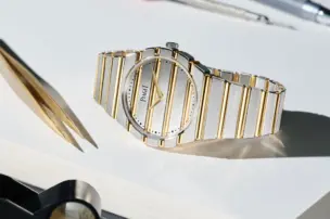 Piaget Polo 79 Two Tone auf der Seite neben einer Pinzette und Lupe liegend