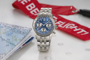 Die Sinn 903 Ti II Jubiläum Chronograph mit blauem Zifferblatt, silbernen Totalisatoren, Tachymeter- und Rechenschieber-Skala sowie mehrgliedrigem Edelstahlarmband, frontal aufgenommen.